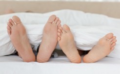 Close up of couple's feet while relaxing in their bed