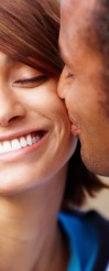 Smiling man kissing his happy girlfriend